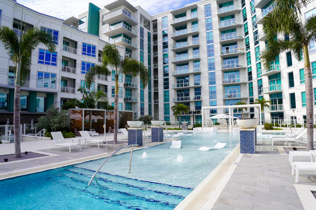 Zero entry pool surrounded by palm trees and overlooking Tampa Bay at The Emerson On Rocky Point apartments