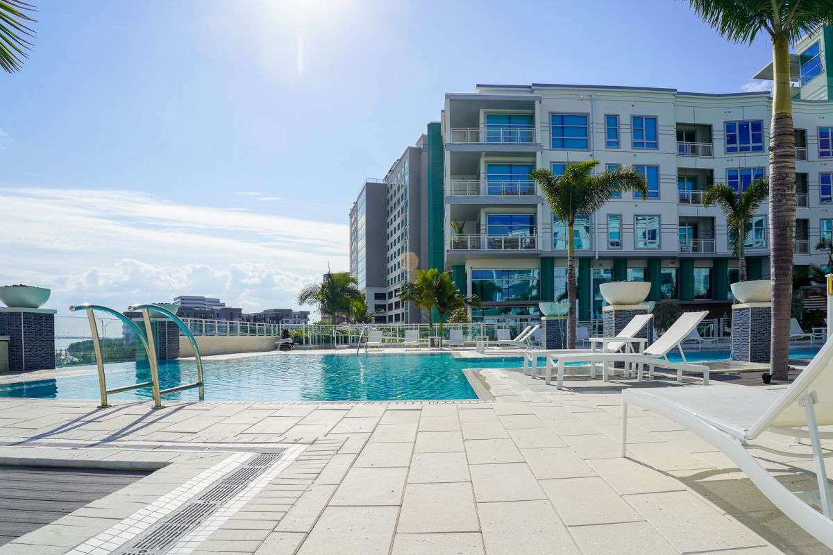 Zero entry pool surrounded by palm trees and overlooking Tampa Bay at The Emerson On Rocky Point apartments